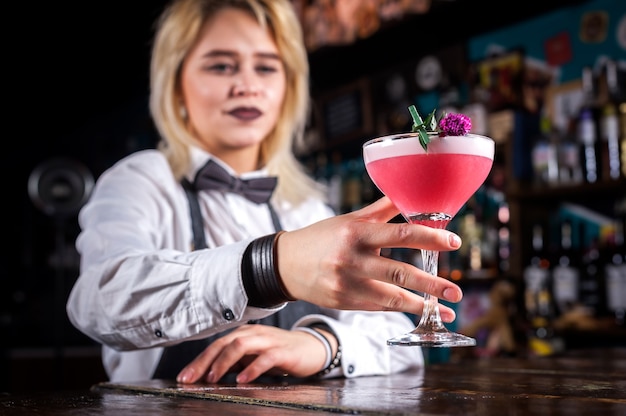 Tapster femme expérimentée montre le processus de préparation d'un cocktail