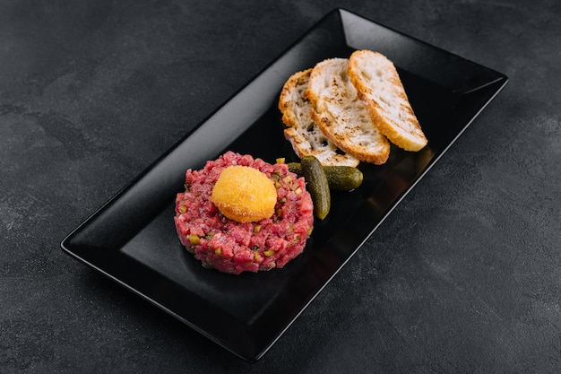 Tartare de boeuf aux concombres salés et pain grillé