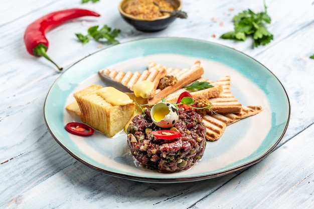 Tartare de boeuf à l'oeuf, câpres, toasts de pain de concombre mariné