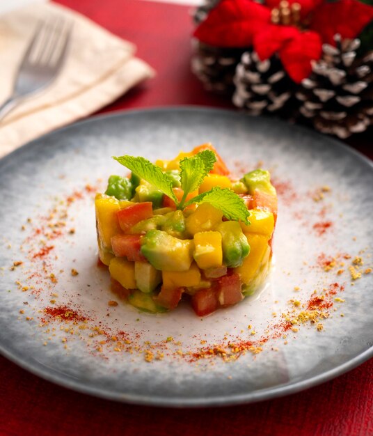 Tartare de mangue et tomate avocat sur une table avec des décorations de Noël