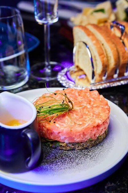 Tartare de saumon à l'avocat sur une plaque blanche dans un restaurant