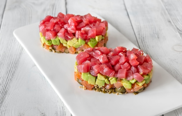 Tartare de thon et saumon sur l'assiette de service