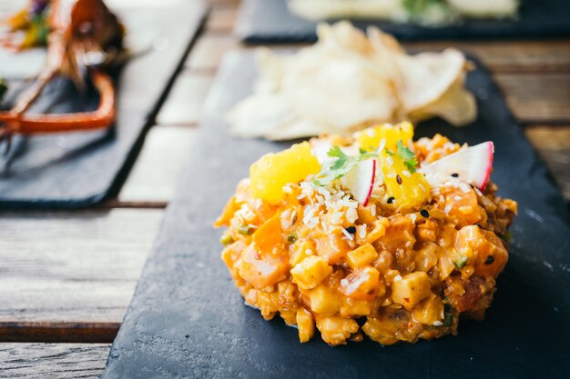 Tartare de viande de saumon frais et cru au plat noir