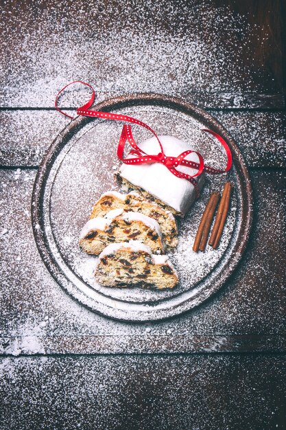 Photo tarte allemande stollen sur un fond en bois avec de la poudre de sucre, vue de dessus, tonique, mise au point sélective