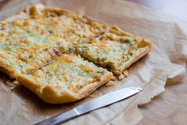 Tarte au fromage délicieusement simple avec des pois verts et des œufs sur papier sulfurisé. Tarte d'été. Vue de dessus