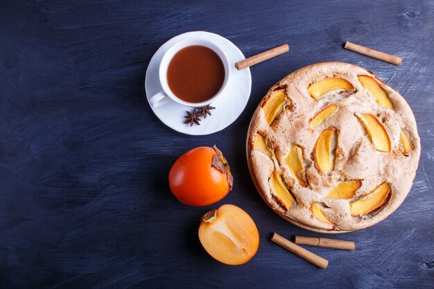 Tarte au kaki doux sur bois noir.