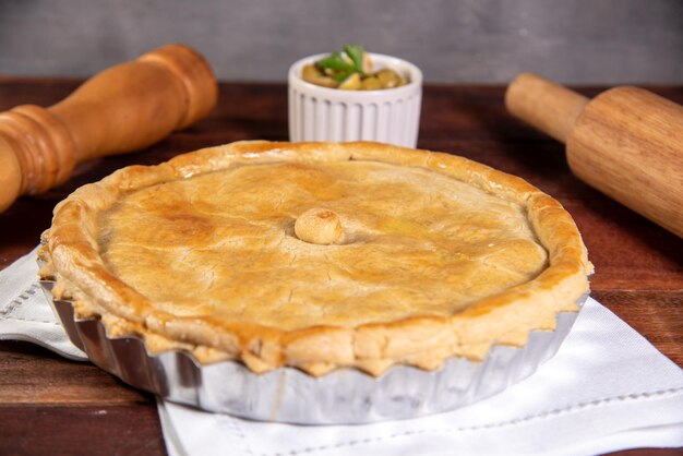 Photo une tarte au poulet sur une table en bois rustique