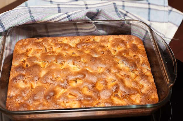 Tarte d'automne faite maison avec des roses de pomme dans une forme de cuisson blanche sur un fond gris en béton ou en pierre Vue d'en haut