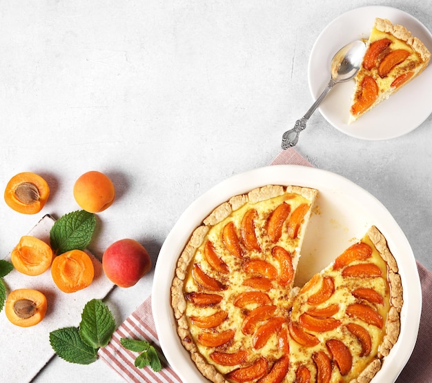 Tarte aux abricots avec fruits frais et morceau de coupe sur l'assiette cheesecake vue de dessus espace de copie