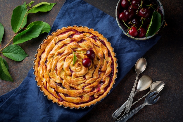 Tarte aux cerises maison avec des cerises dans un bol