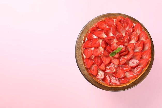 Tarte aux fraises sur fond rose, espace pour le texte.