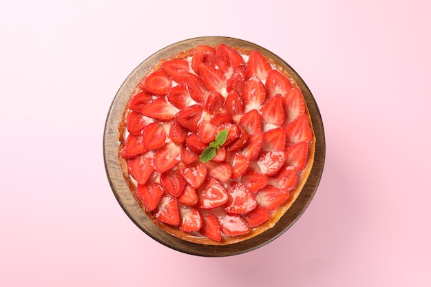 Tarte aux fraises sur fond rose, vue de dessus.