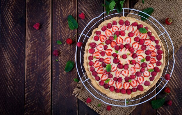 Tarte aux fraises, framboises et chantilly décorée de feuilles de menthe. Vue de dessus, au-dessus