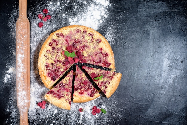 Tarte aux framboises avec des framboises mûres dans la cuisine maison avec du fromage cottage sur un noir