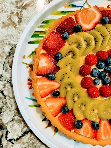 Une tarte aux fruits frais colorés sur un comptoir en marbre