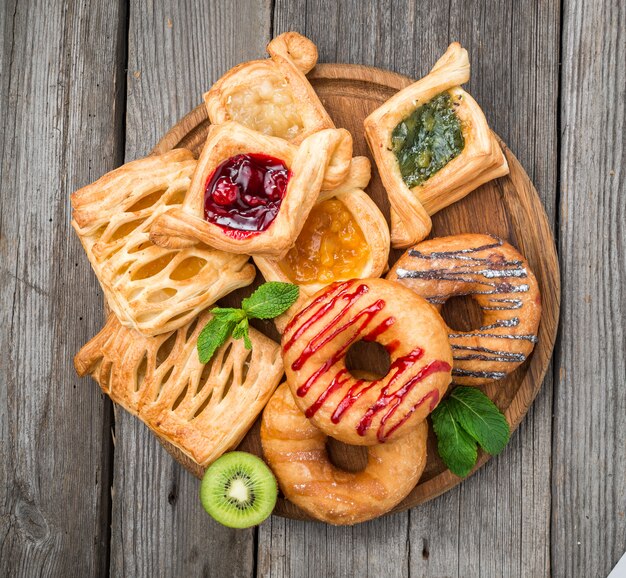 Tarte aux fruits frais avec de la confiture de baies et de menthe sur une surface en bois