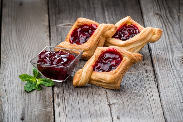 Tarte aux fruits frais avec confiture de baies, menthe sur table en bois. Désert.