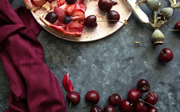 Tarte aux fruits frais faits maison avec des baies sur fond sombre pour le texte