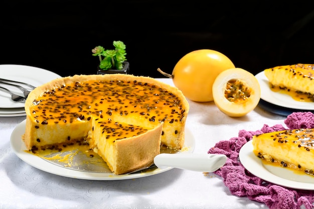 Tarte aux fruits de la passion avec une tranche déjà enlevée Spatule avec une tranche de tarte