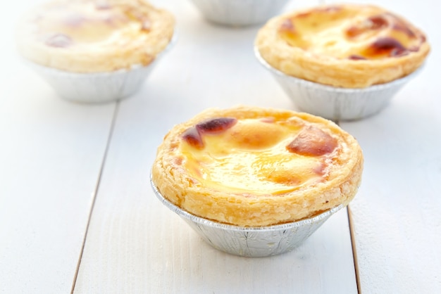 Tarte aux oeufs sur un fond en bois blanc.