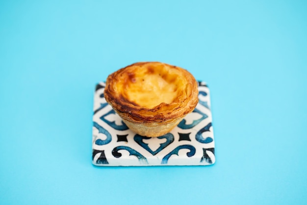 Tarte aux oeufs portugaise typique pastel de nata sur papier bleu