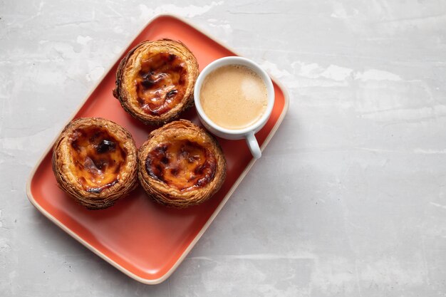 Tarte aux œufs portugaise typique pastel de nata avec tasse de café