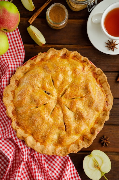 Tarte aux pommes américaine classique à la cannelle sur un mur en bois foncé. Style rustique. Vue de dessus, copiez l'espace.