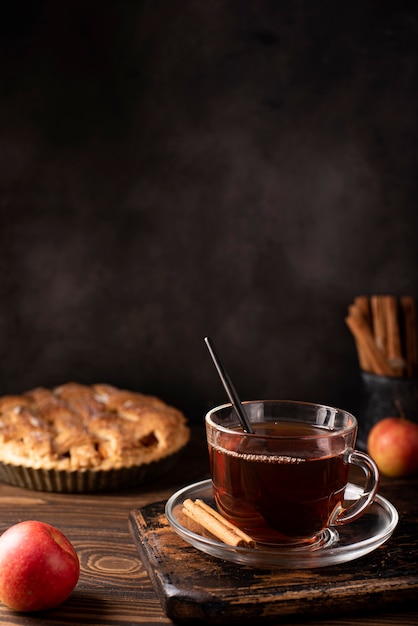 Tarte aux pommes à la cannelle et thé noir chaud sur une table en bois