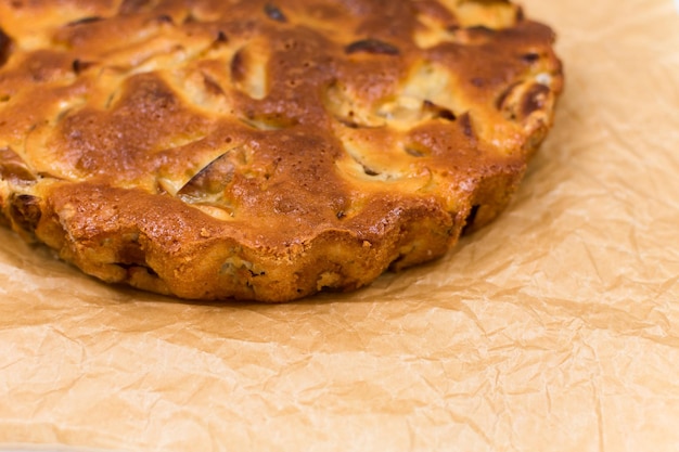 Tarte aux pommes cuite maison dans une assiette sur une table en bois prête à manger