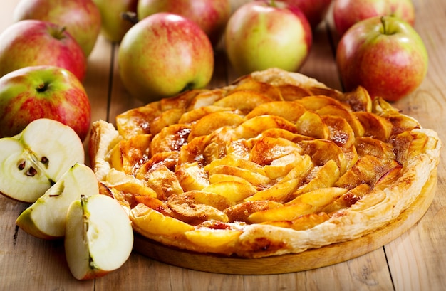 Tarte aux pommes avec fruits frais sur table en bois