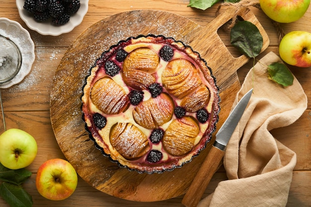 Tarte aux pommes Gâteau aux pommes et aux mûres ou tarte décorée de poudre de sucre sur une vieille table en bois Délicieux dessert pour le dîner d'automne ou d'hiver Dessert de pâtisserie d'automne Vue de dessus