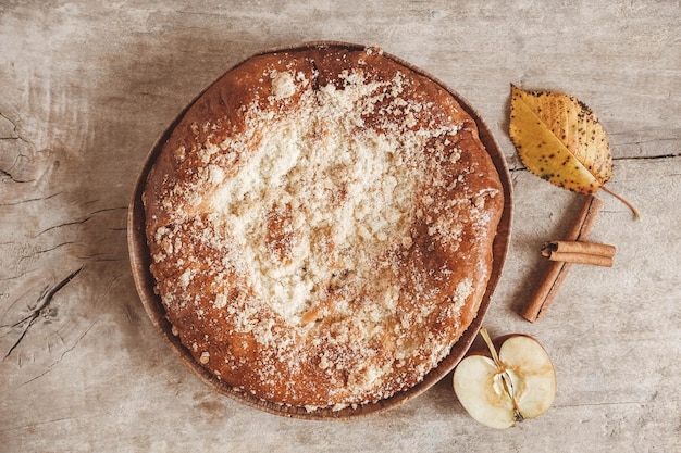 Tarte aux pommes maison et cannelle sur la texture de fond en bois vintage