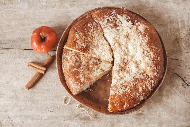 Tarte aux pommes maison et cannelle sur la texture de fond en bois vintage