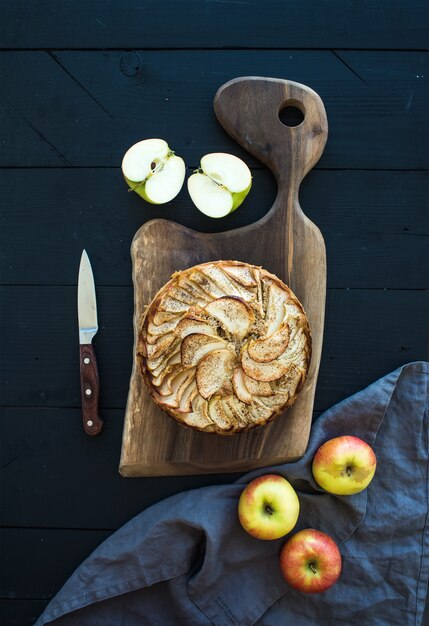 Tarte aux pommes sur une planche à découper sombre