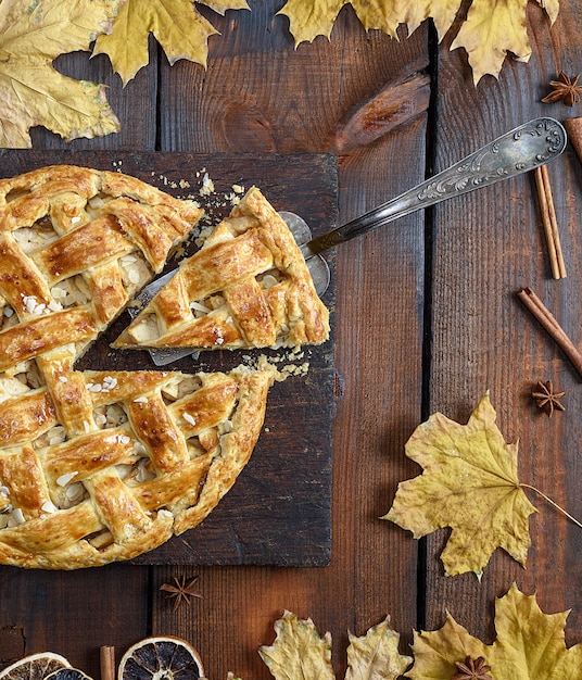 Tarte aux pommes ronde sur une planche en bois marron