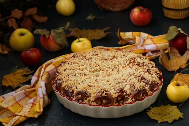 La tarte aux pommes se présente sous forme de céramique, les pommes sont éparpillées sur la table