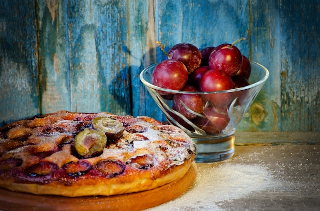 Tarte aux prunes et prunes fraîches dans un bol