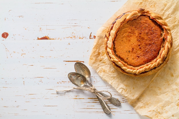 Tarte à la citrouille sur fond de bois blanc en vue de dessus