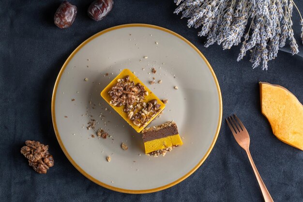 Tarte à la citrouille maison au chocolat et aux noix Saupoudrée de noix Posée sur une assiette coupée