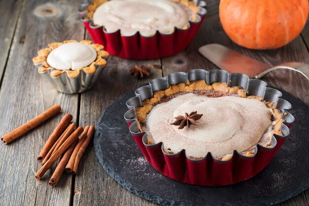 Tarte à la citrouille avec meringue et cannelle sur une vieille surface en bois. Mise au point sélective.