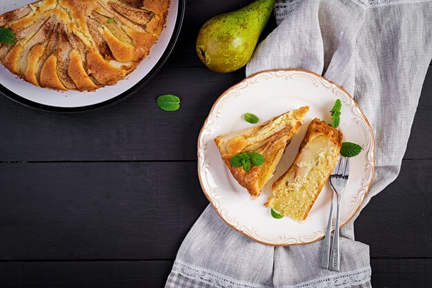 Tarte faite maison avec des poires et de la farine d'amande sur un fond sombre vue du haut