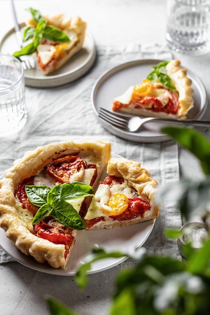 Tarte feuilletée d'été à la tomate mozzarella et composition Bazil avec verdure en flou