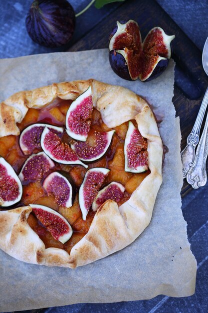 Tarte maison aux prunes et aux figues sur une plaque à pâtisserie