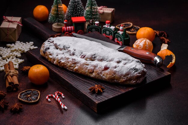 Photo tarte de noël volée avec des baies de massepain et des noix sur un fond de béton foncé