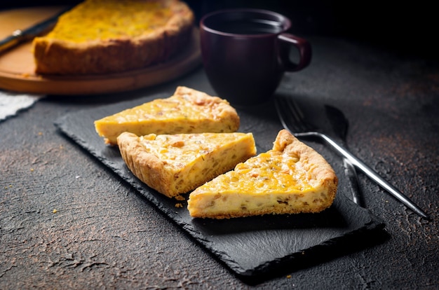 Tarte à l'oignon maison traditionnelle française ou quiche. Tarte ouverte au fromage et à l'oignon sur un plateau rond.