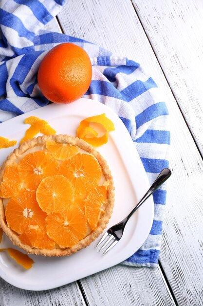 Tarte à l'orange maison sur plaque sur fond de bois de couleur