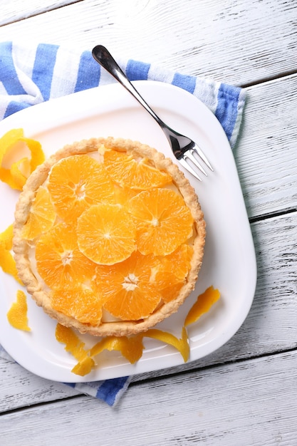 Tarte à l'orange maison sur plaque, sur fond de bois de couleur