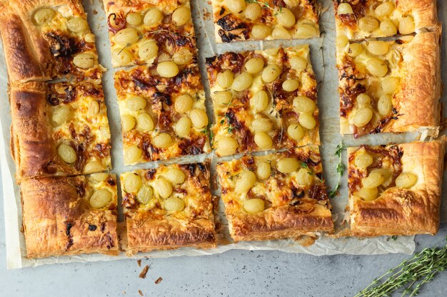 Tarte à la pâte feuilletée, à l'oignon caramélisé, au fromage, au thym et au raisin vert