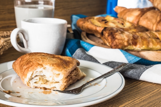 Une Tarte Sur Plat Blanc, Assortiment De Pâtisseries Avec Du Café Et Du Lait Sur La Table En Bois.