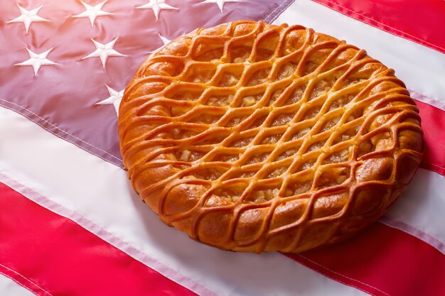 Tarte portant sur le drapeau des États-Unis. Produit de boulangerie et bannière colorée. Le temps passe mais les traditions demeurent. Pâte savoureuse et pommes fraîches.